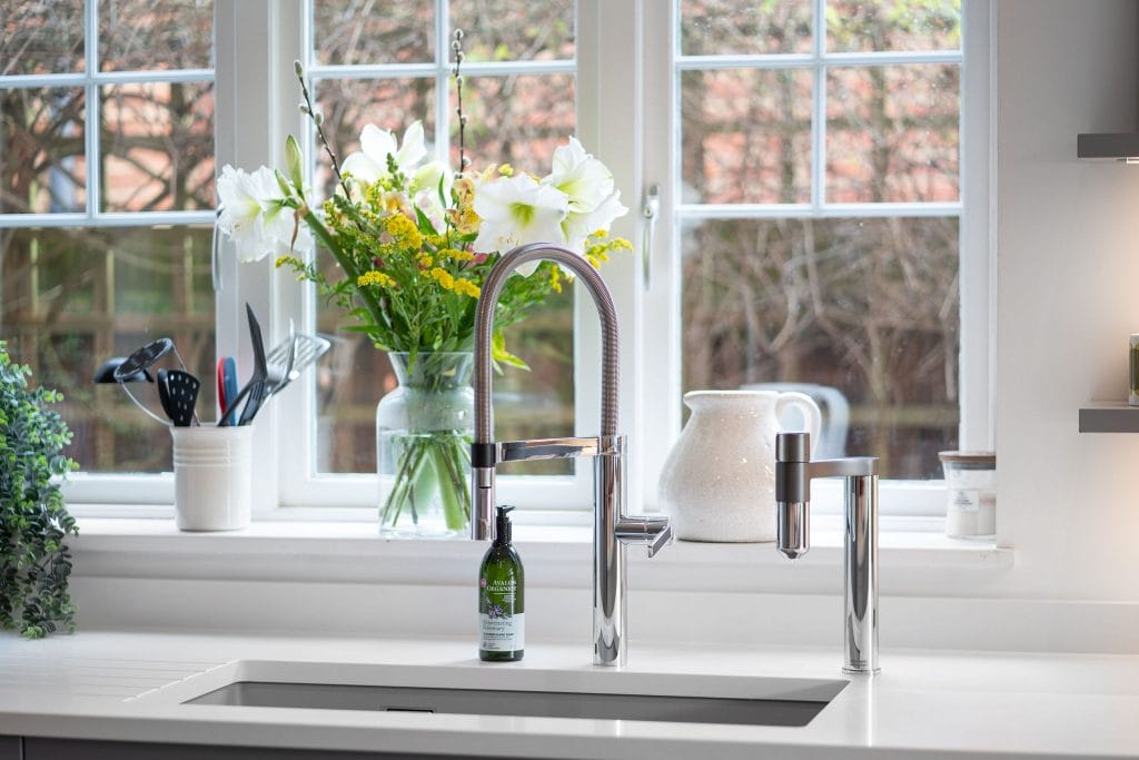 CLASSIC GREY SHAKER KITCHEN WITH SLEEK WHITE WORKTOPS AND COPPER ACCENTS