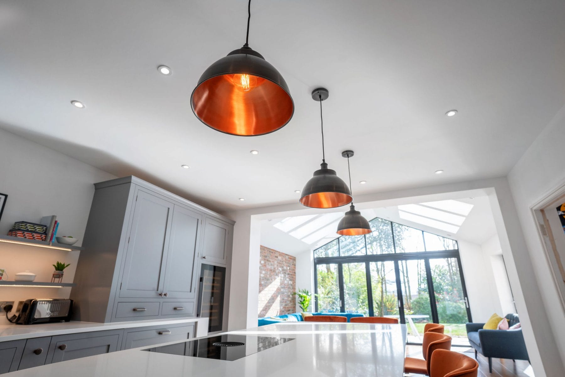 CLASSIC GREY SHAKER KITCHEN WITH SLEEK WHITE WORKTOPS AND COPPER ACCENTS