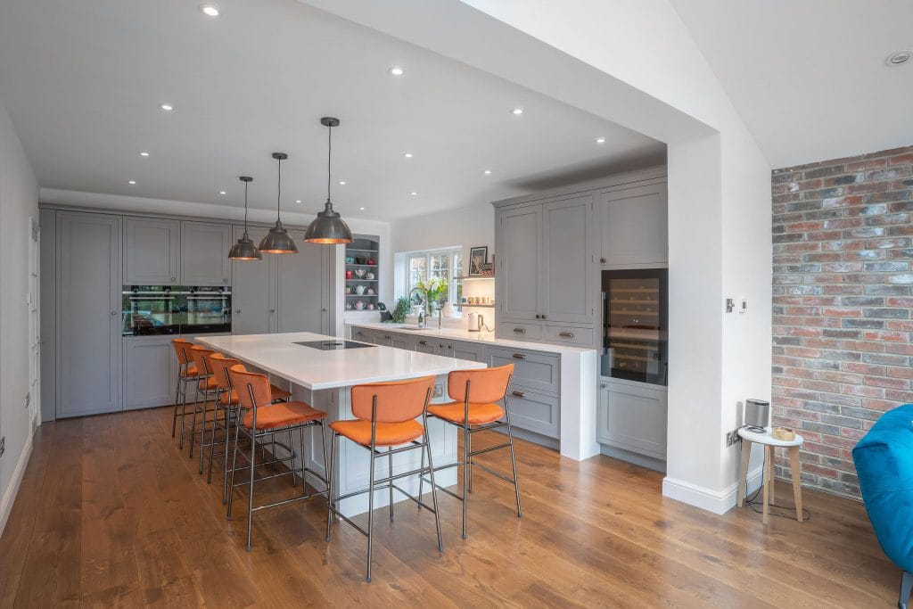 CLASSIC GREY SHAKER KITCHEN WITH SLEEK WHITE WORKTOPS AND COPPER ACCENTS