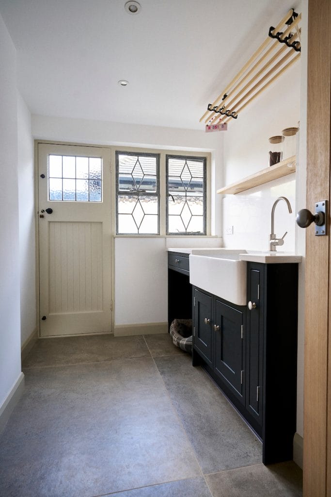Classic kitchen with large white sink, and dark blue cabinetry