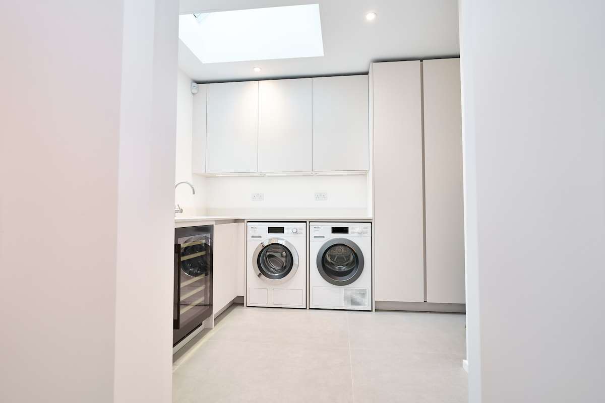 luxury handleless kitchen with secret passage doors to utility built into the kitchen units