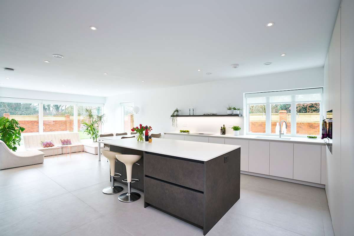 luxurious minimalist kitchen with white and grey cabinetry in an open-plan living space