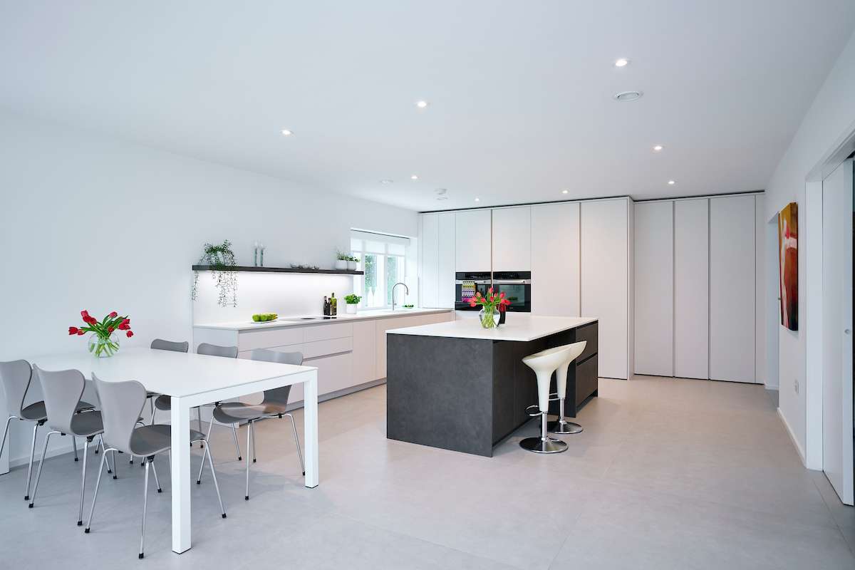 modern open-plan kitchen and dining area featuring white and grey minimalist design elements