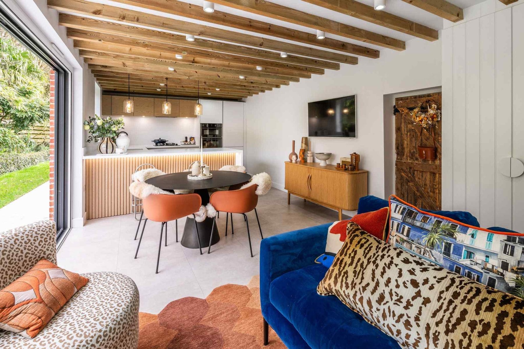 Stylish kitchen dining area featuring textured wood island and mid-century décor