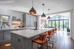 Shaker kitchen with copper colour palette, barstools, wood flooring